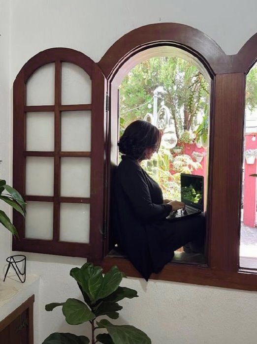 Raquel Cecília em janela, em momento de escuta e leitura