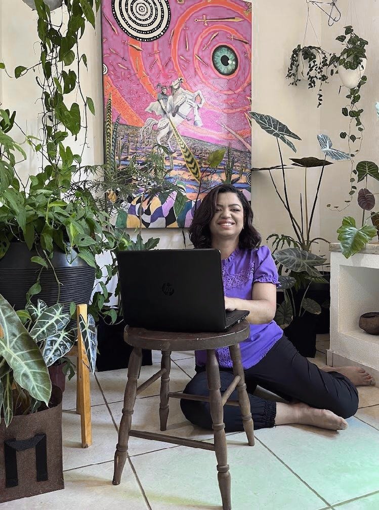 Raquel Cecília em ambiente com plantas, conduzindo seu trabalho